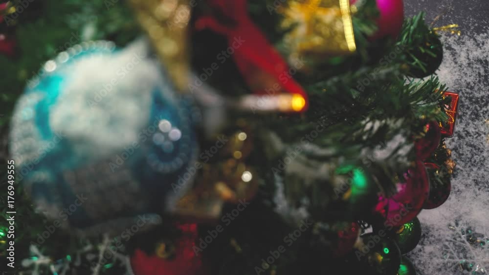 Greeting Season concept.Christmas tree and decorations with presents and ornaments on wood table from above with falling snow in 4k (UHD)