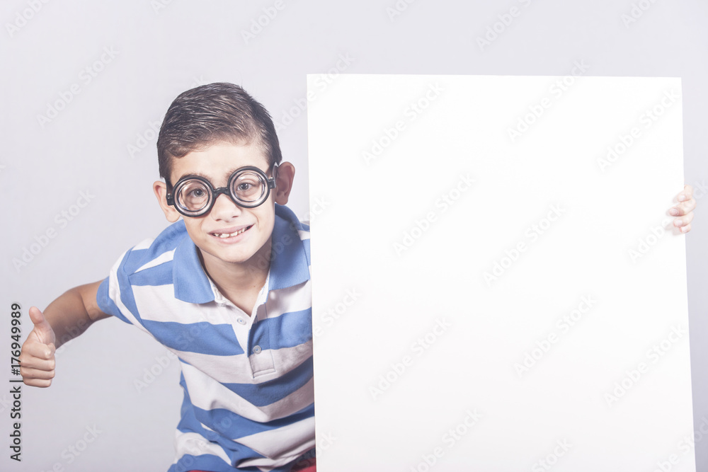 Funny little nerd boy holding a blank white sign with copy space