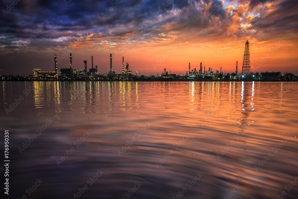 Oil and gas industry - refinery at Sunrise - factory - petrochemical plant with reflection over the river Oil and gas industry - refinery at Sunrise - factory - petrochemical plant with reflection over the river