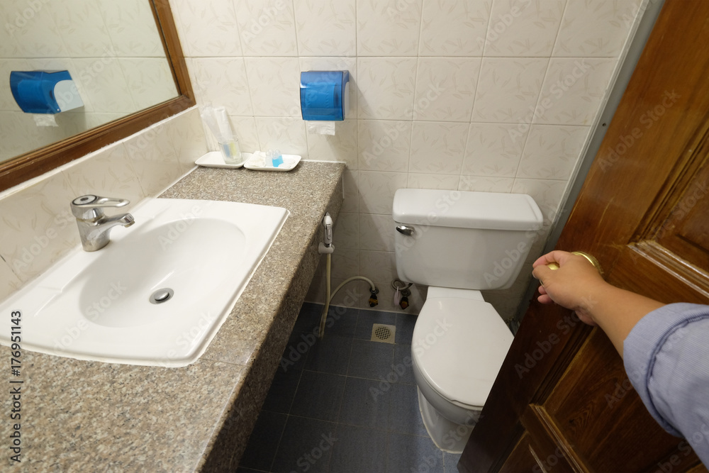 Opening the wooden door to the toilet room Opening the wooden door to the toilet room