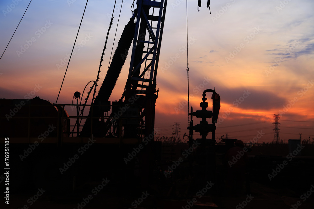 the silhouette of oilfield derrick