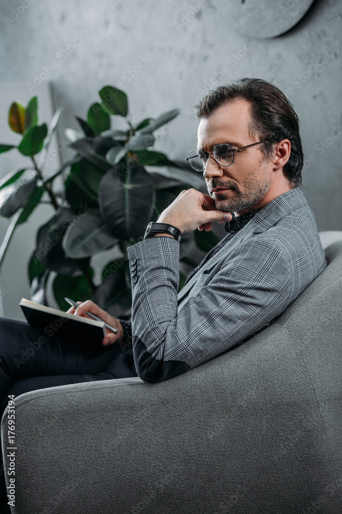 businessman taking notes in notebook