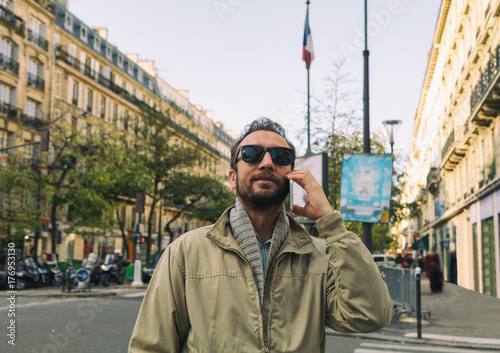 Modern guy using cellphone in the European city.