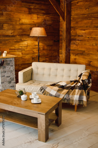 Wallpaper Mural Home comfort. Armchair near the fireplace with firewood. Photo of interior of room with a wooden wall, wreath and garlands, Christmas atmosphere Torontodigital.ca