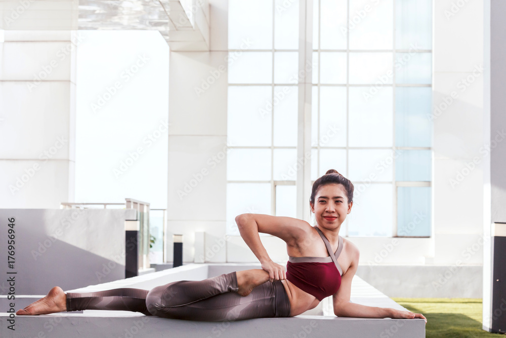 Woman practicing yoga in front of a large window Woman practicing yoga in front of a large window