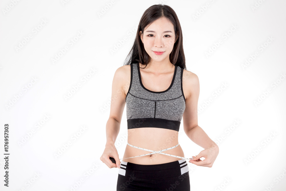 Woman slim measuring her waist using a tape measure isolated on white background Woman slim measuring her waist using a tape measure isolated on white background
