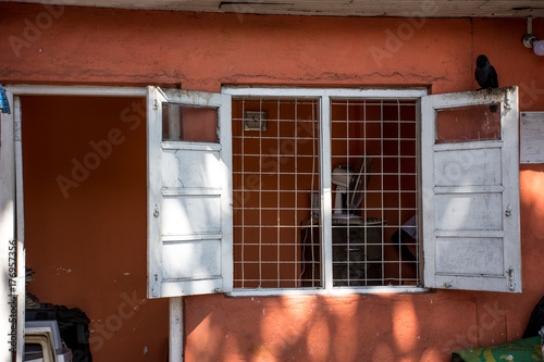 An old hut with an open window.