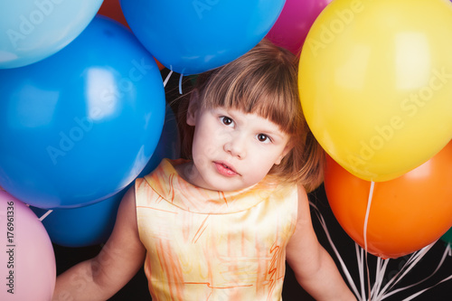 Caucasian blond girl with colorful balloons
