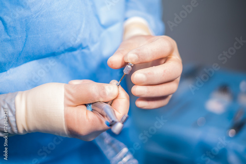 Close up of hands during dental surgery.