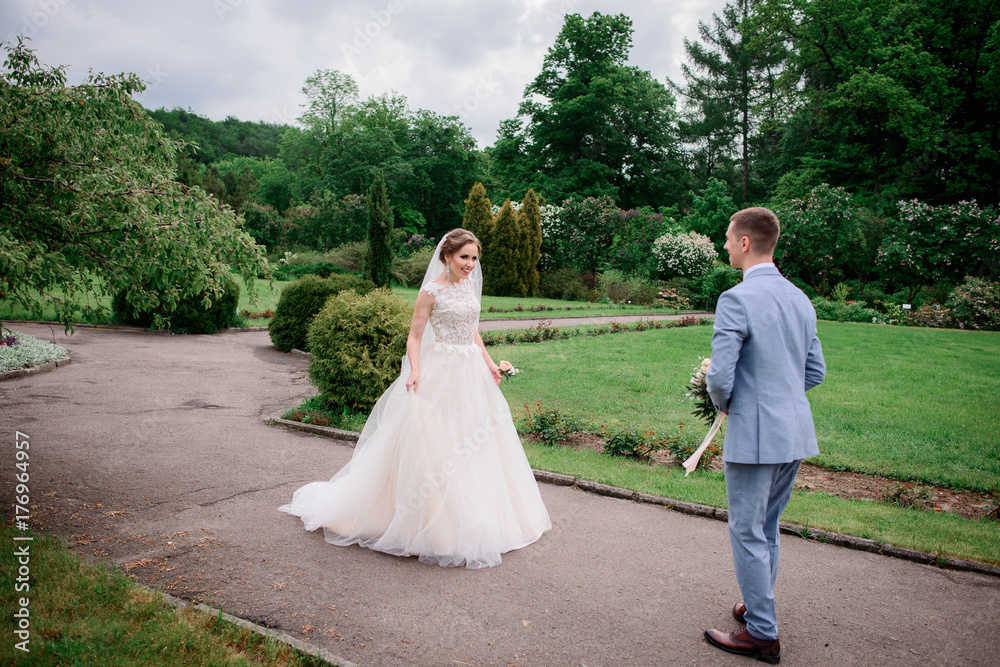 Bride comes to groom standing with wedding bouquet Bride comes to groom standing with wedding bouquet