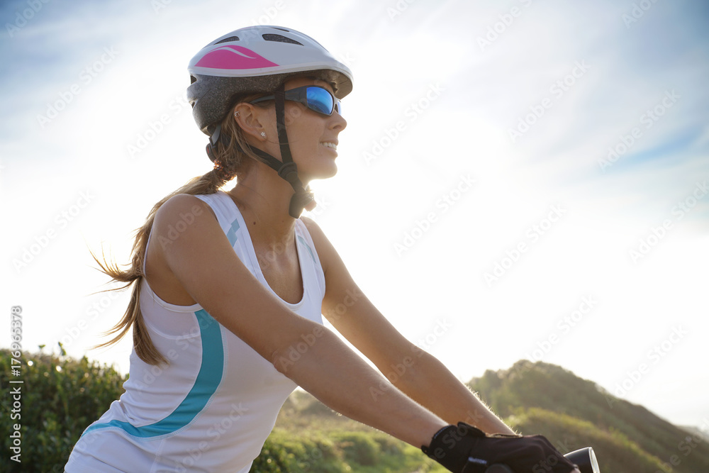 Woman in sports outfit riding bike on country track Woman in sports outfit riding bike on country track