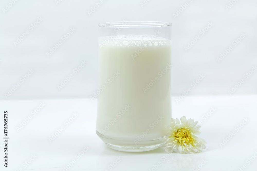 A bottle of milk and glass of milk on a wooden table on a background A bottle of milk and glass of milk on a wooden table on a background