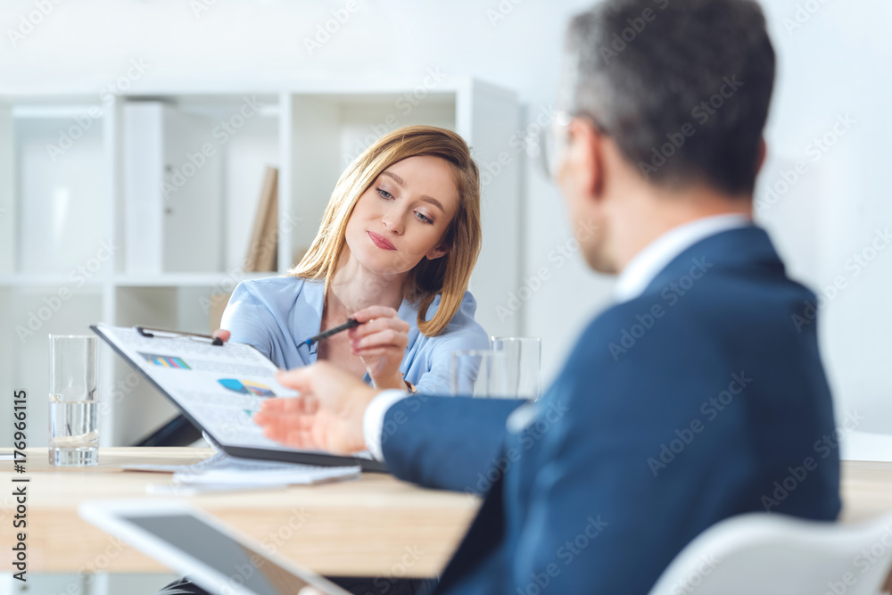 businesswoman giving documents to partner businesswoman giving documents to partner