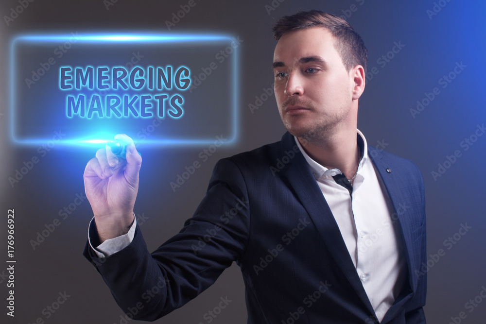 The concept of business, technology, the Internet and the network. Young businessman showing inscription: Emerging markets The concept of business, technology, the Internet and the network. Young businessman showing inscription: Emerging markets