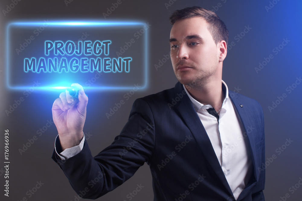 The concept of business, technology, the Internet and the network. Young businessman showing inscription: Project management The concept of business, technology, the Internet and the network. Young businessman showing inscription: Project management