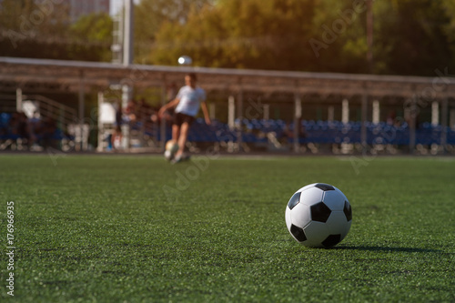 Traditional soccer ball on green grass playground. © pavel_shishkin