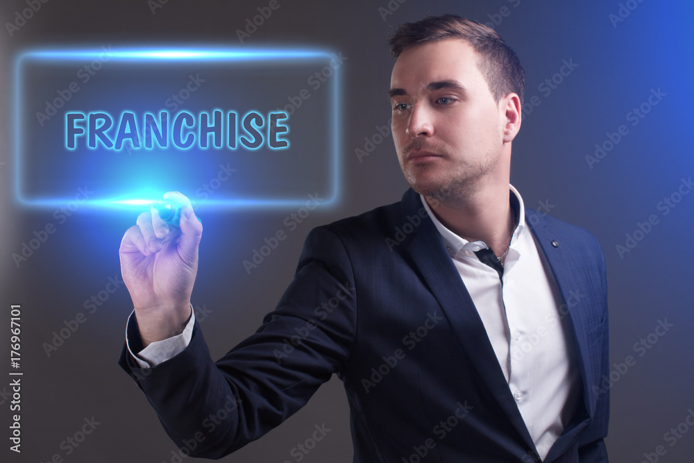 The concept of business, technology, the Internet and the network. Young businessman showing inscription: Franchise The concept of business, technology, the Internet and the network. Young businessman showing inscription: Franchise