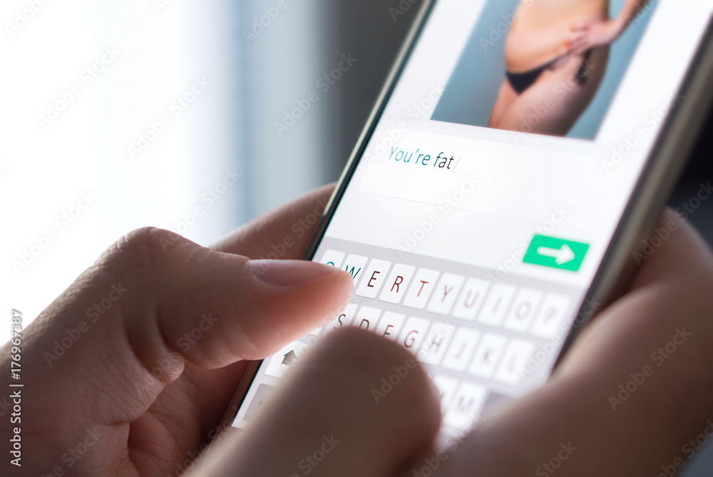 Body shame, cyber bullying and bad behavior online concept. Internet troll sending mean comment to picture on an imaginary social media website with smartphone. Body shame, cyber bullying and bad behavior online concept. Internet troll sending mean comment to picture on an imaginary social media website with smartphone.