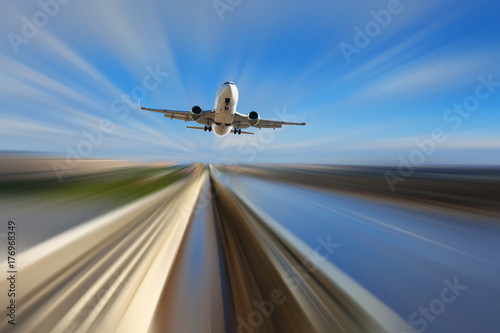 Airliner over highway on blurred background