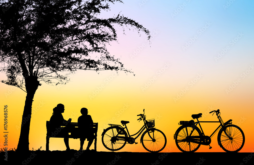 silhouette vintage bike and love couple in  the holiday on blurry sunrise time