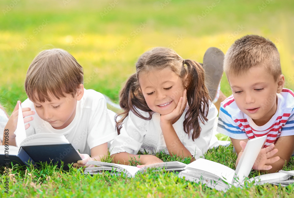 Cute little children reading books in park Cute little children reading books in park