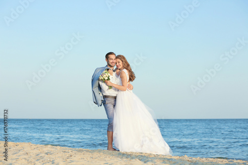 Happy wedding couple on sea beach