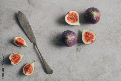 Figs on light grey minimal concrete background. Healthy snack with freshly cut slices of ripe fruit .Top view.