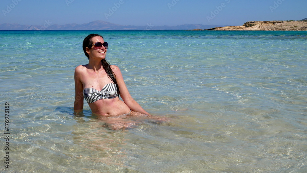 Europe's Secret Islands/ Woman sitting in the water in the sea.
