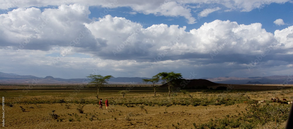 Panorama of the Masai Mara Highlands with some human figures in the distance