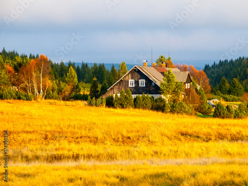 Wooden hut in Jizerka village. Sunny autumn day. Jizera Mountains, Czech Republic.