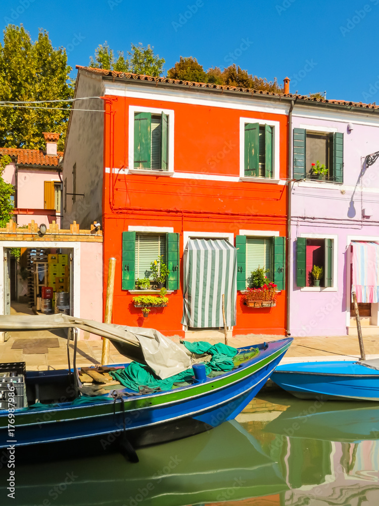 Burano Island, colorful houses and boats on channels of island. Venice, Italy