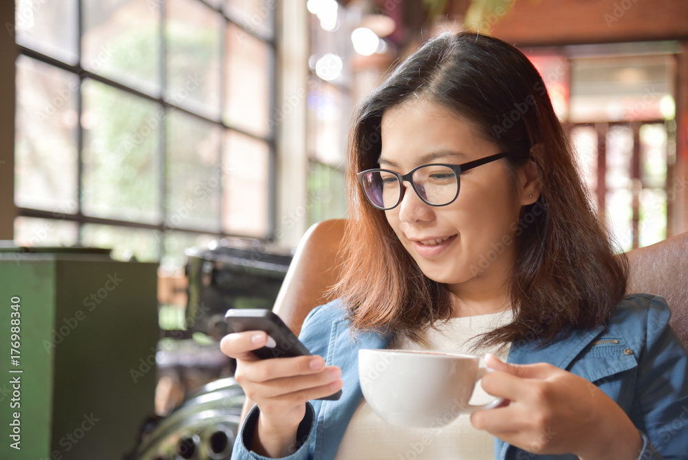Woman holding cup of coffee and using smart phone. Woman holding cup of coffee and using smart phone.
