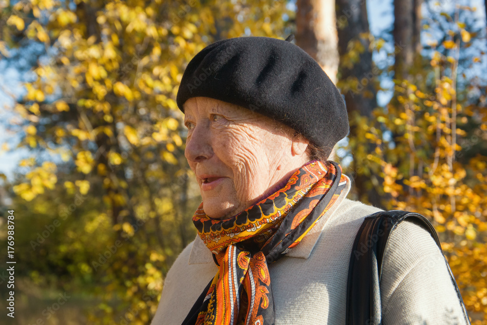 Portrait of elderly senior woman in hat at autumn park Portrait of elderly senior woman in hat at autumn park