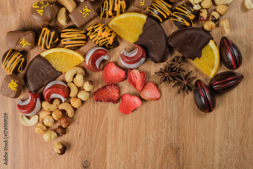 Chocolate sweets with orange slices and dried fruits on a wooden table. handmade?