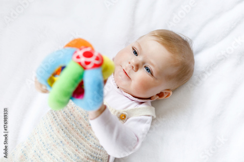 Cute baby playing with toy ball, crawling, grabbing