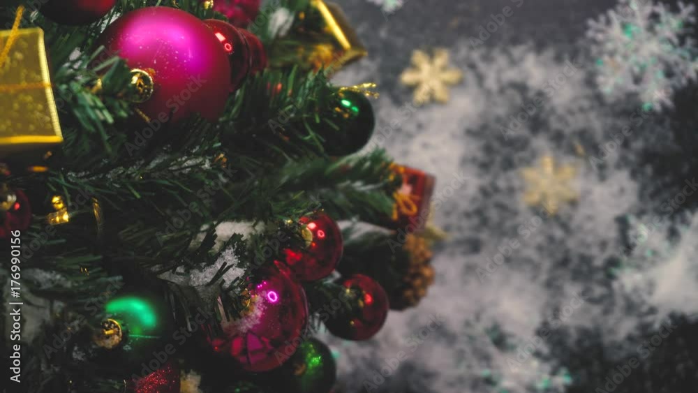 Greeting Season concept.Christmas tree and decorations with presents and ornaments on wood table from above with falling snow in 4k (UHD) Greeting Season concept.Christmas tree and decorations with presents and ornaments on wood table from above with falling snow in 4k (UHD)