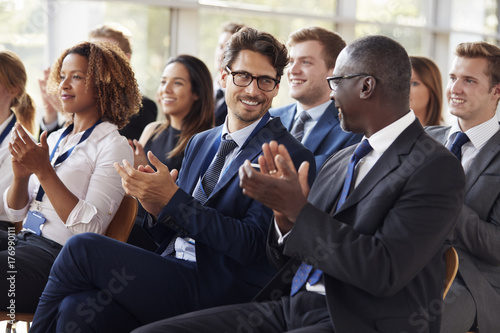 Audience clapping at business seminar  looking at each other