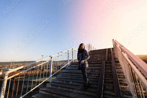 the woman walks the stairs of the crossing through the railway