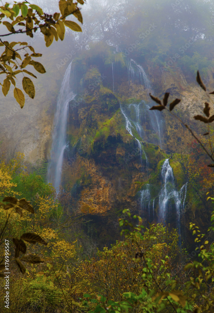 Beautiful landscape with mountain waterfall and colorful autumn forest