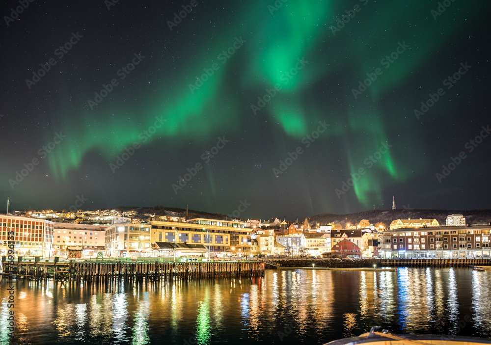 northern lights over a cityscape in northern norway