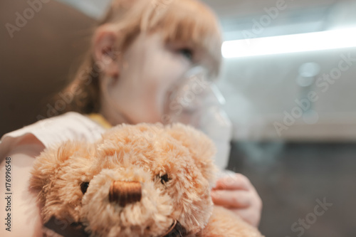 Cute little girl using nebulizer on white background. Allergy concept