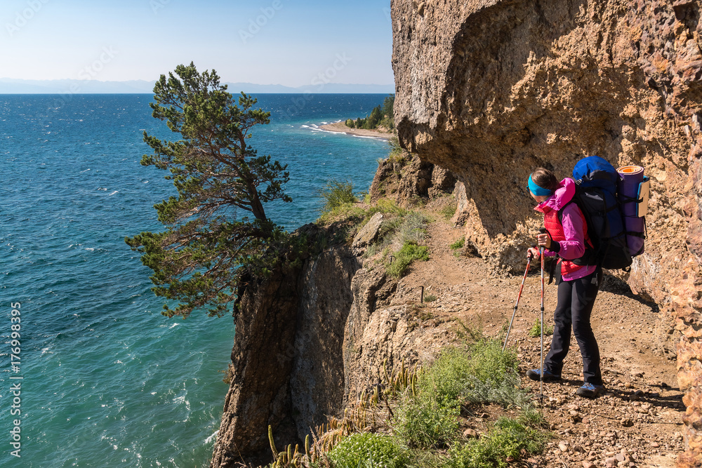 A tourist stand along a dangerous path over a cliff