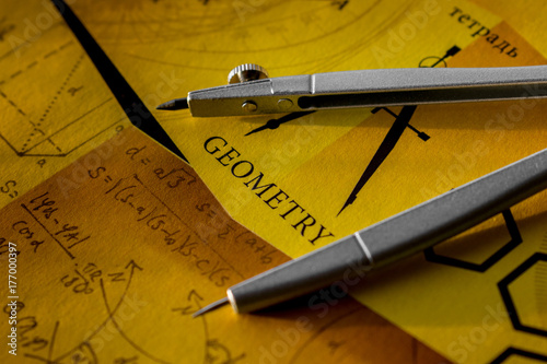 Compass on a notebook with the words geometry