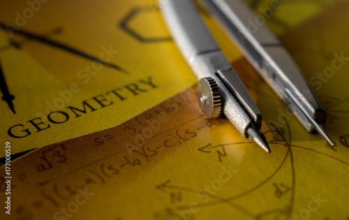 Compass on a notebook with the words geometry
