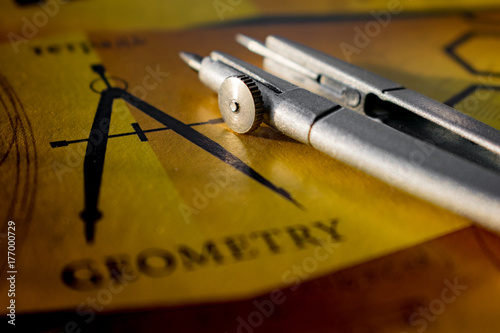 Compass on a notebook with the words geometry