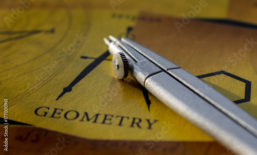 Compass on a notebook with the words geometry