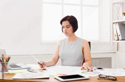 Business woman reading document at office desktop