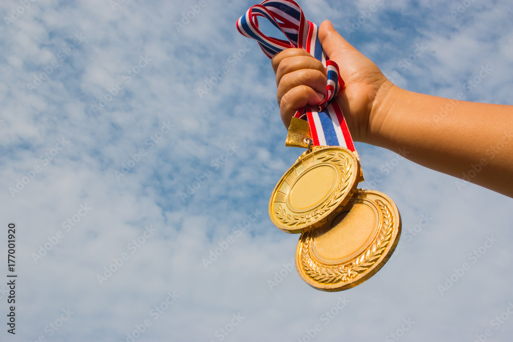 Winner hand raised and holding two gold medals with Thai ribbon against ...