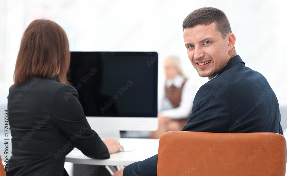 rear view. businessman sitting at Desk and looking at camera. rear view. businessman sitting at Desk and looking at camera.