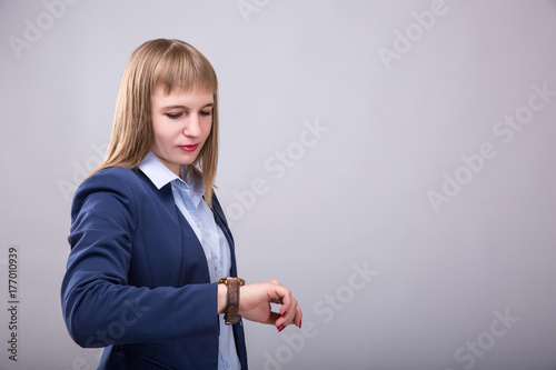 Time to do business. Thoughtful young woman in smart casual wear checking the time. Model look to the watch photo